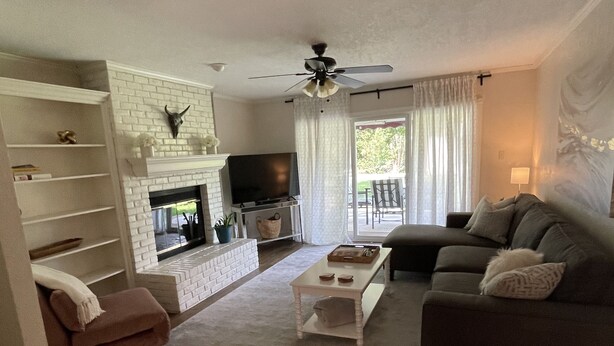 Un salon avec une cheminée, un téléviseur, un canapé et une table basse.