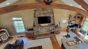 Una cocina amplia con chimenea de piedra, armarios de madera y un refrigerador grande.