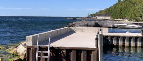 A pier extending into calm waters with a ladder leading down to the dock.