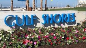 Skilt for 'CulF ShOrEs' med blomsterbed foran.