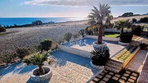 A coastal property with a paved patio, palm trees, and a view of the sea. - Dreamy South Sea View Villa Residence with Pool - Garden Level (Sfakia)