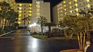 A hotel with multiple floors, a central courtyard, and palm trees.