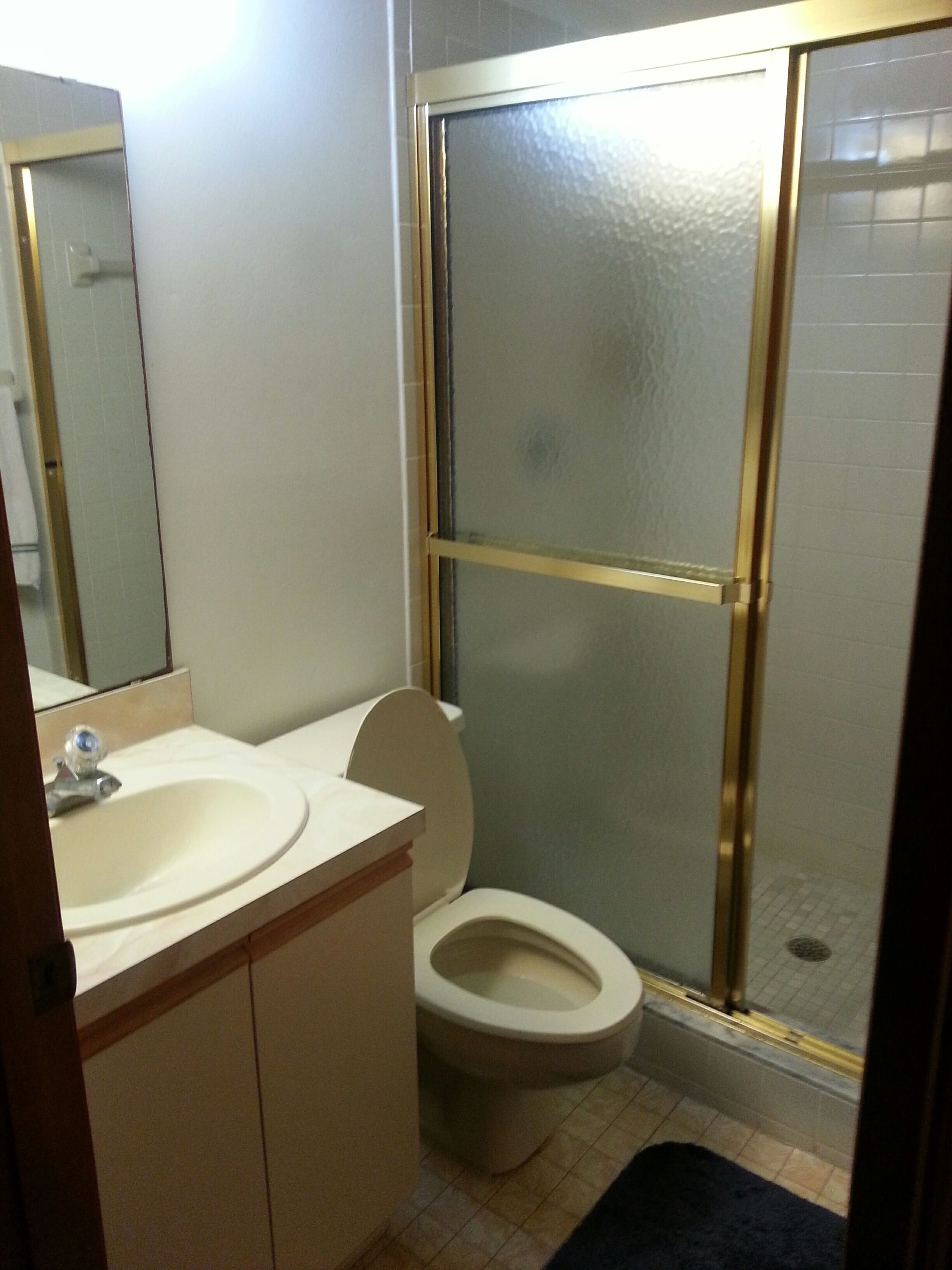 Een badkamer met toilet, wastafel en douche.