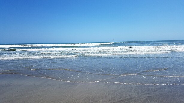 A beach with waves approaching the shore.