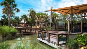 Un espace paysager agrémenté d’un point d’eau, de passerelles en bois et d’une zone de repos abritée, ainsi que d’une fresque murale.