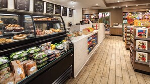 A bakery counter with various baked goods and a deli section with packaged salads and sandwiches.