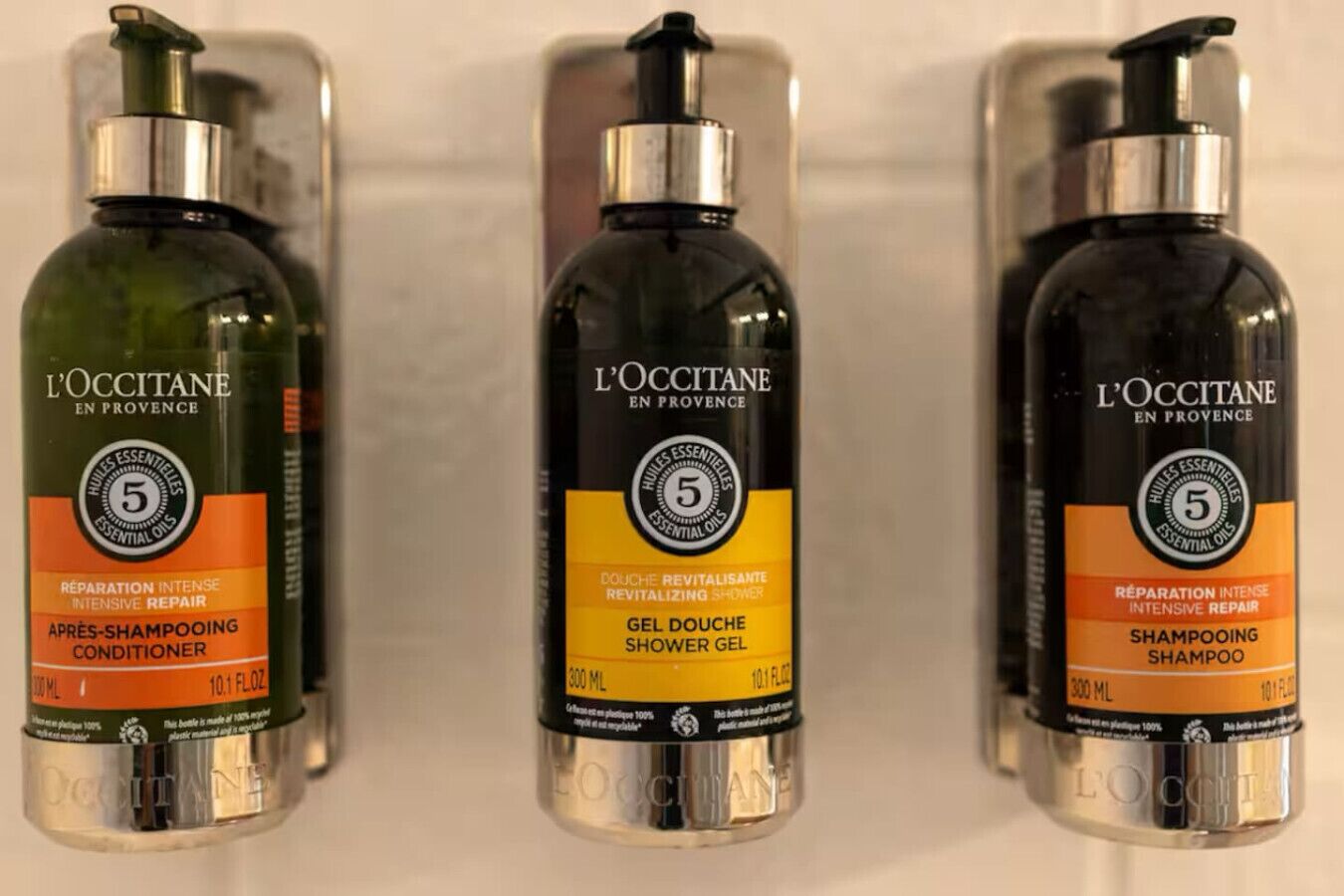 Drie flessen L'OCCITANE producten op een plank.