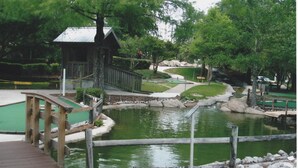 A wooden bridge over a pond with a small pavilion and a pathway. - Relax! Put Your toes in the Sand at this DIRECT GULF FRONT CONDO   (Orange Beach)