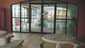A pool area with glass doors, outdoor seating, and a Coca-Cola sign. - Relax! Put Your toes in the Sand at this DIRECT GULF FRONT CONDO   (Orange Beach)
