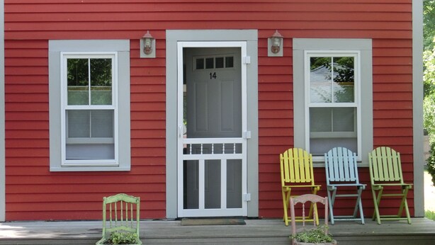 A red house with a white door marked with the number 14. There are three Adirondack chairs on the porch. - Quaint,,,Quiet..up island feel yet a short walk to town and harbor (Oak Bluffs)