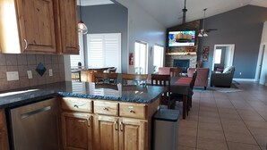 Una cocina amplia con armarios de madera, encimera de granito y lavavajillas.