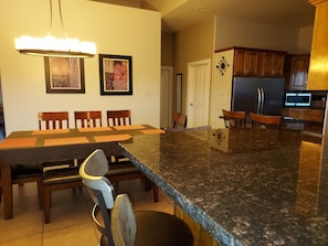A modern kitchen with granite countertops, wooden cabinets, and a built-in microwave.