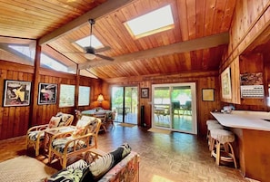 A wooden cabin interior with a dining area, seating, and a bar.
