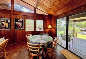 Un intérieur en bois avec une table ronde et des chaises, une lampe et des affiches au mur.