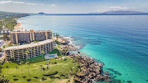 A resort with a large building, a pool, and a view of the ocean. - 407 - Gorgeous Oceanfront one bedroom unit! (Kihei)