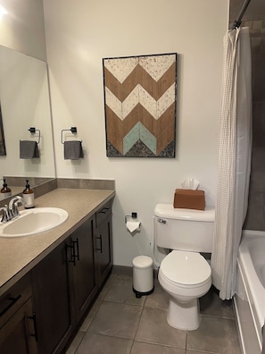 A bathroom with a sink, toilet, and shower curtain.