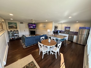 A modern kitchen with white cabinets, stainless steel appliances, and a central island.