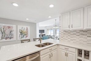 Enjoy cooking in this well-equipped kitchen with a wine rack, stainless steel sink, and ample counter space.