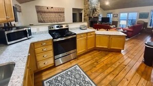 Una cocina con armarios de madera, estufa y microondas.