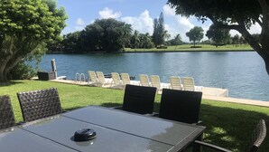 A table with chairs and a view of a lake. - Bay Front - 'Villa La - Vue', Incredible Bay & Golf Course Views!  Sleeps 15. (Miami Beach)