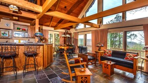 Una cocina amplia con barra, zona de comedor y un ventanal con vistas al exterior.