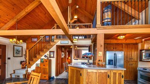 Una cocina amplia con armarios de madera, una isla grande y un refrigerador de acero inoxidable.