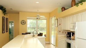A kitchen with a long island counter, white cabinets, and a built-in oven. - Large 3 Brd Briarwood Lake-View Pool Villa
NEWLY renovated Bathroom (Naples)