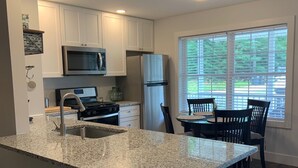 A modern kitchen with granite countertops, stainless steel appliances, and a large island with bar stools.