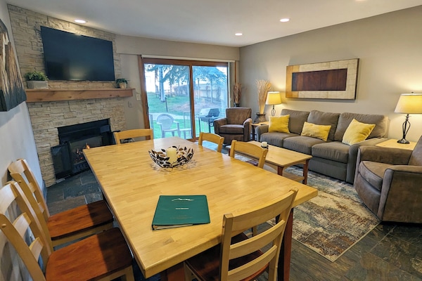 Living room with sofa bed, gas fireplace, dining table, and patio w/ gas BBQ