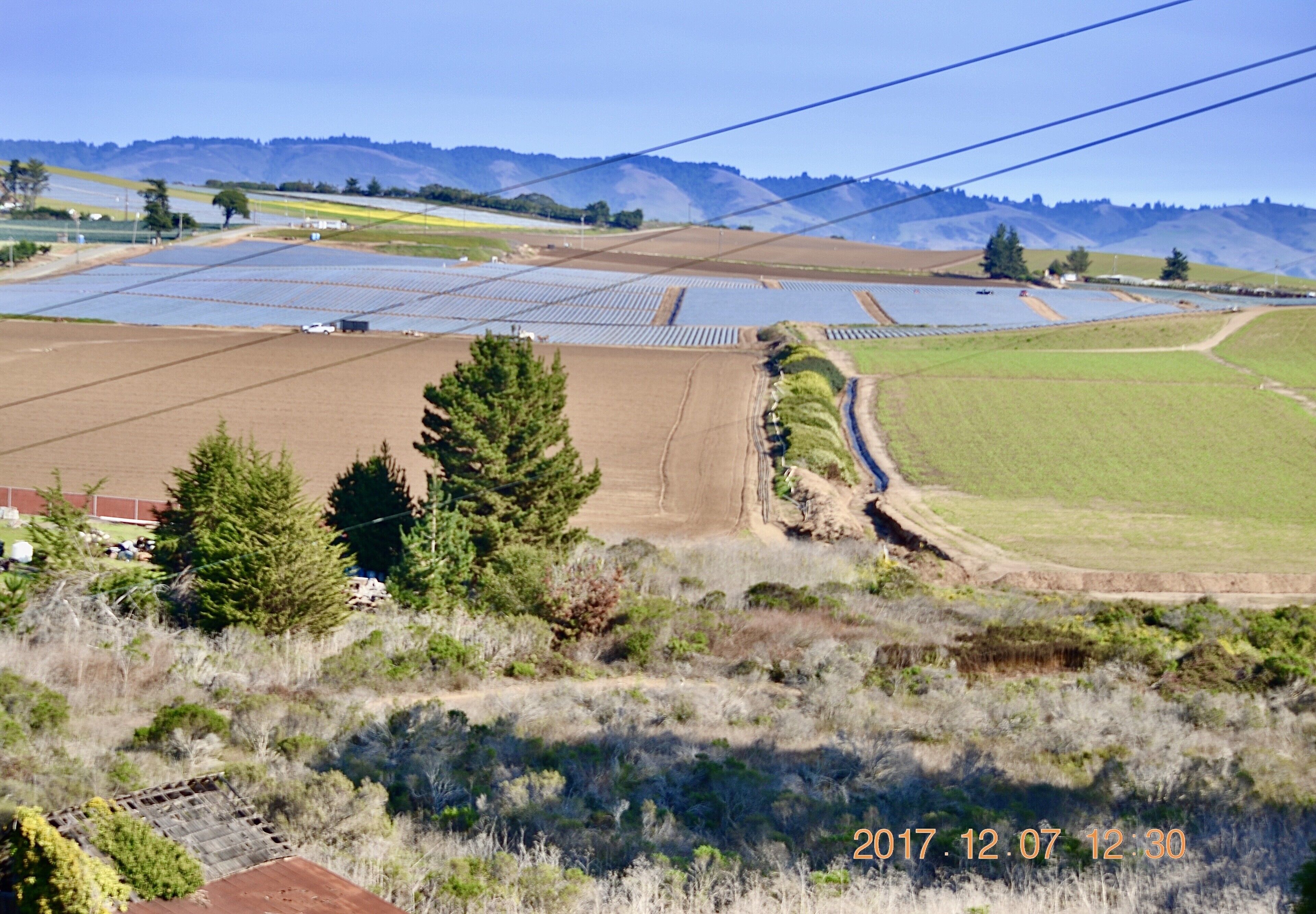Un paisaje con paneles solares, campos y cielo despejado.