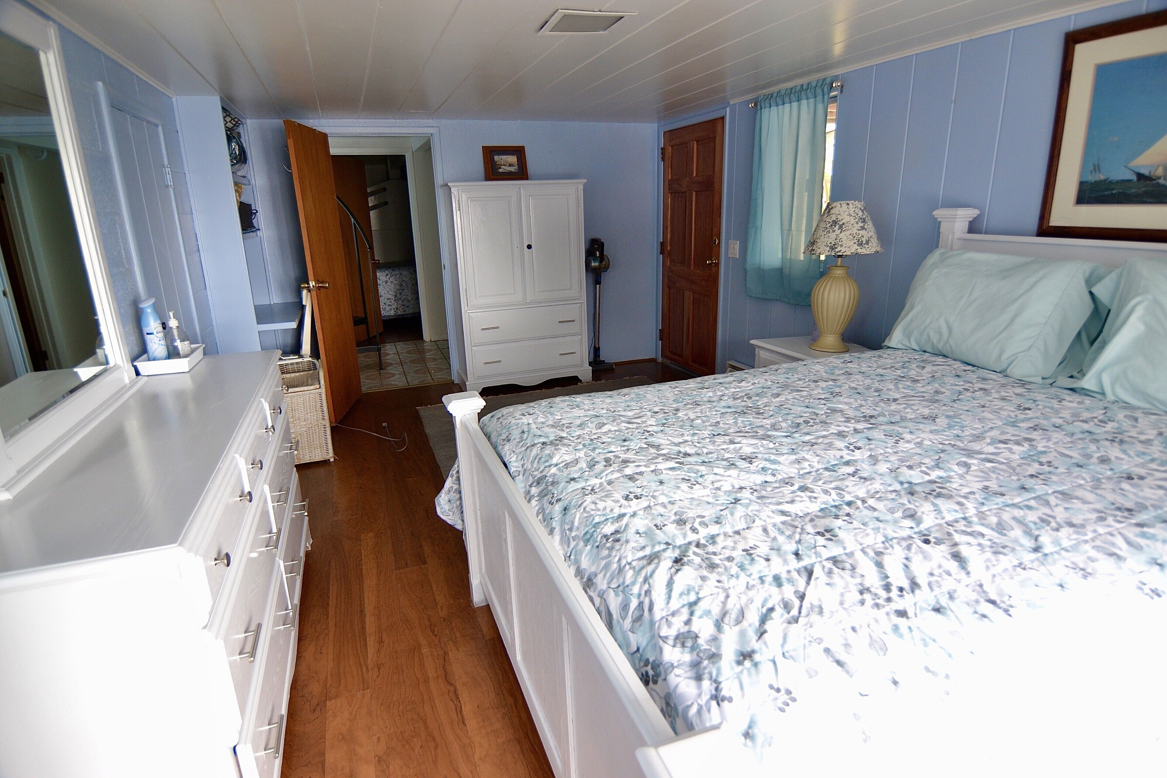 A bedroom with a bed, dresser, and wardrobe.