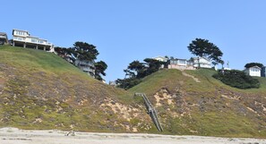 A coastal hillside with houses and a staircase leading down to the beach. - Ocean front charming cottage with beach access for family & pet- permit 261009. (Watsonville)
