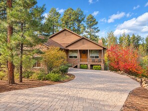 A two-story house with a stone foundation, a wooden exterior, and a brick driveway leading to a front porch. - Stunning cabin in Torreon with unbeatable views—your search ends here! (Show Low)