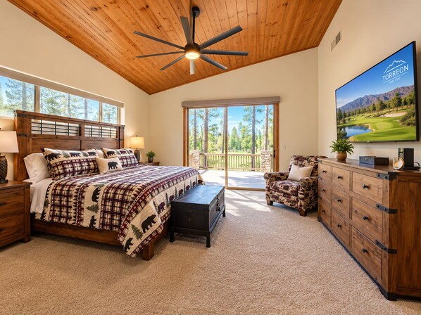 A bedroom with a large bed, a ceiling fan, a TV, and a view of the outdoors. - Stunning cabin in Torreon with unbeatable views—your search ends here! (Show Low)