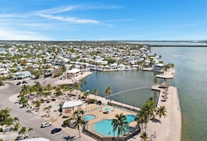 Ein Küstenresort mit mehreren Wohnmobilen, einem zentralen Schwimmbad und einer Marina. Das Bild zeigt ein Küstenresort mit mehreren Wohnmobilen, einem zentralen Schwimmbad und einer Marina.