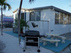 Enjoy a beachfront retreat with a single-story building, large windows, and an outdoor seating area.