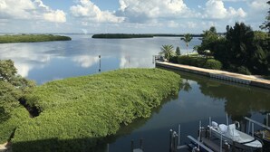 A calm lake with a dock and boats, surrounded by lush greenery and distant islands.