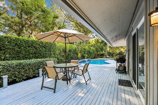 Relax by the pool surrounded by lush greenery and enjoy a meal prepared on the outdoor grill.