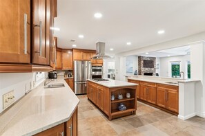 Enjoy cooking in this well-equipped kitchen with a central island, oven, range, and large sink.