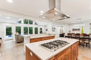 Enjoy cooking in the well-lit kitchen with a central island, gas stove, and ample counter space.