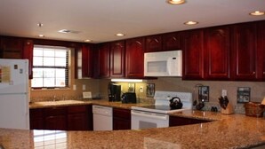 A kitchen with granite countertops, dark wooden cabinets, a white microwave, and a dishwasher. - LABOR DAY WKEND $175/NGHT SPECIAL! 
A CANCELLATION =GREAT HOLIDAY OPP 4 U!





 (Gatlinburg)