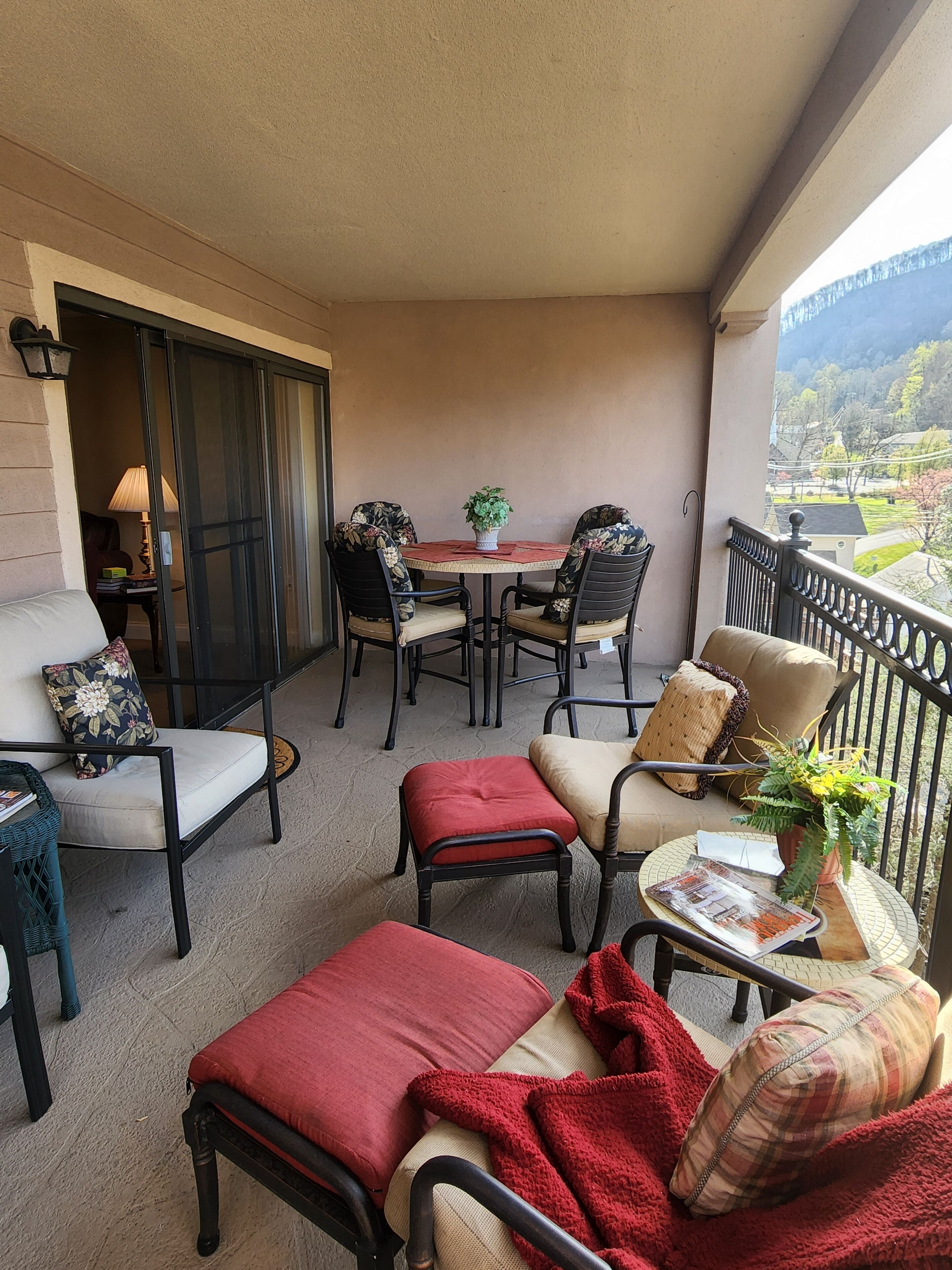 Un balcon avec une table, des chaises et une vue sur le paysage.