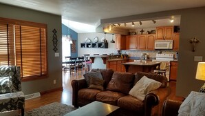 A modern kitchen with wooden cabinets, a central island, and a microwave. - Friendly, Quiet Cul-de-sac - 18 Minutes from Oshkosh EAA Air Show Appleton ATW! (Neenah)