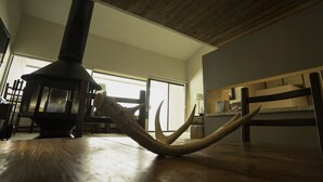 Ein Zimmer mit Holzboden, Kamin und einem Essbereich mit Stühlen und Tisch.