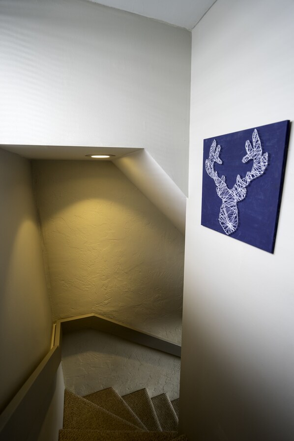 A staircase with a textured wall and a framed artwork of a deer head. - Mt. CB - Great views, Great Space! Easy access to lifts! (Crested Butte)