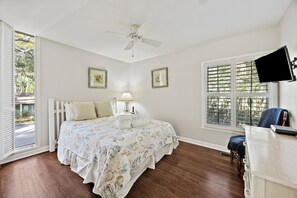 A bedroom with a bed, a desk, a chair, a ceiling fan, and two windows. - Beautifully updated SeaPines beach villa, Pet friendly, On site pool (Hilton Head Island)