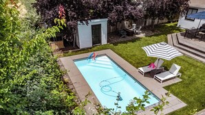 A rectangular swimming pool with a small deck area, surrounded by a well-maintained lawn and a wooden fence. - Peaceful, Sonoma oasis - heated pool, fire pit, outdoor dining - close to Plaza (Sonoma)