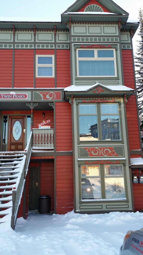 Un bâtiment rouge avec une enseigne « Twin Peaks », une autre indiquant « À vendre » et une troisième indiquant « Vendu ».