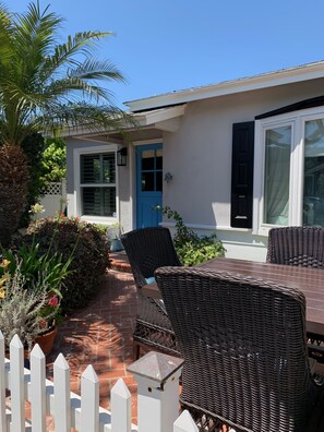 A patio with wicker furniture, a blue door, and a white picket fence. - Cozy Slice Of Paradise Just Steps From The Beach!! (Newport Beach)