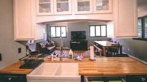 Une cuisine moderne dotée d’un grand îlot central, de meubles de rangement intégrés et d’un coin repas avec une table et des chaises.